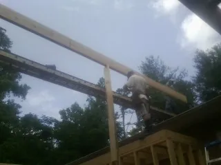 Carpenter setting a ridge beam over a new addition frame — Ice Dam Removal by Roofing Brothers in Wetumpka